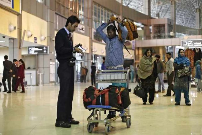 Indigo Airlines' ground staff uses a queue buster devise to release a boarding pass to a passenger at the Srinagar airport