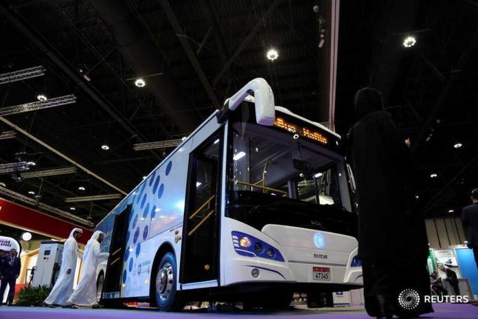 Visitors take a look at the ECO Bus manufactured by Masdar during the Abu Dhabi Sustainability Week, in Abu Dhabi